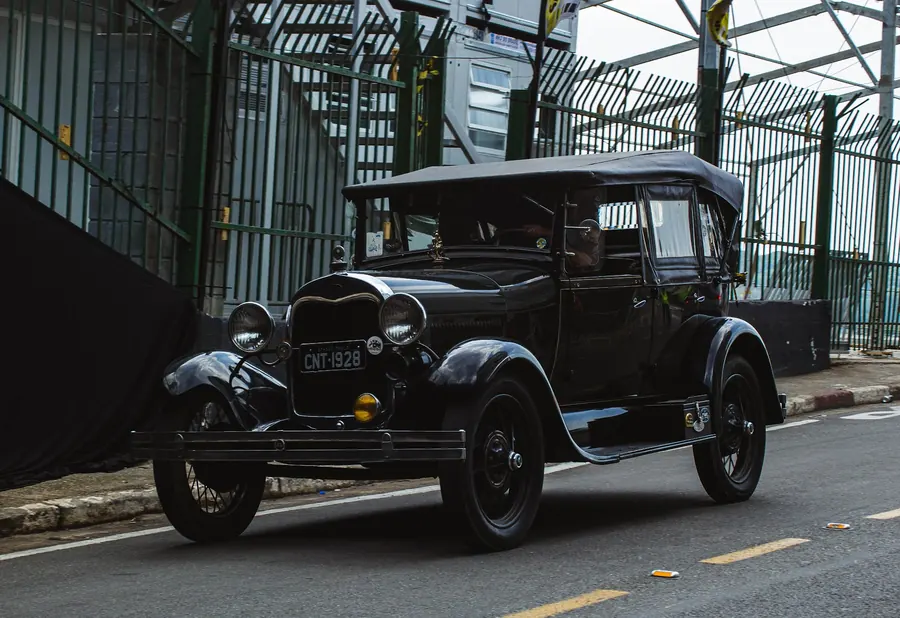 Carro preto antigo saindo do túnel do autódromo