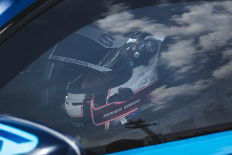Capacete de piloto visto através do vidro, com nuvens refletidas